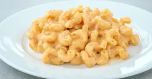 A close-up of creamy gluten-free mac and cheese, made with chickpea pasta served on a white plate.