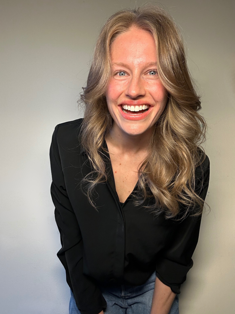 A personable photo of Adriana Lapusniak of Adriana Alternative leaning over laughing and expressing joy.